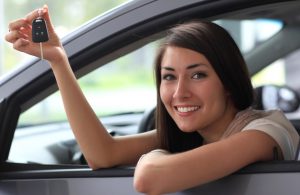 Happy smiling woman with car key. Driving
